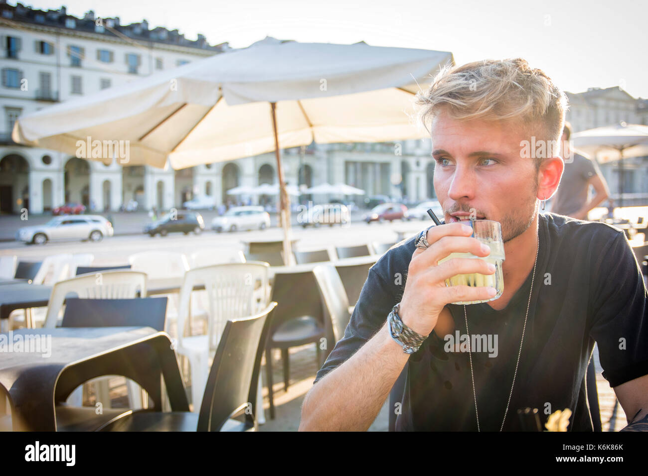 Handsome man sitting in cafe holding glass Stock Photo