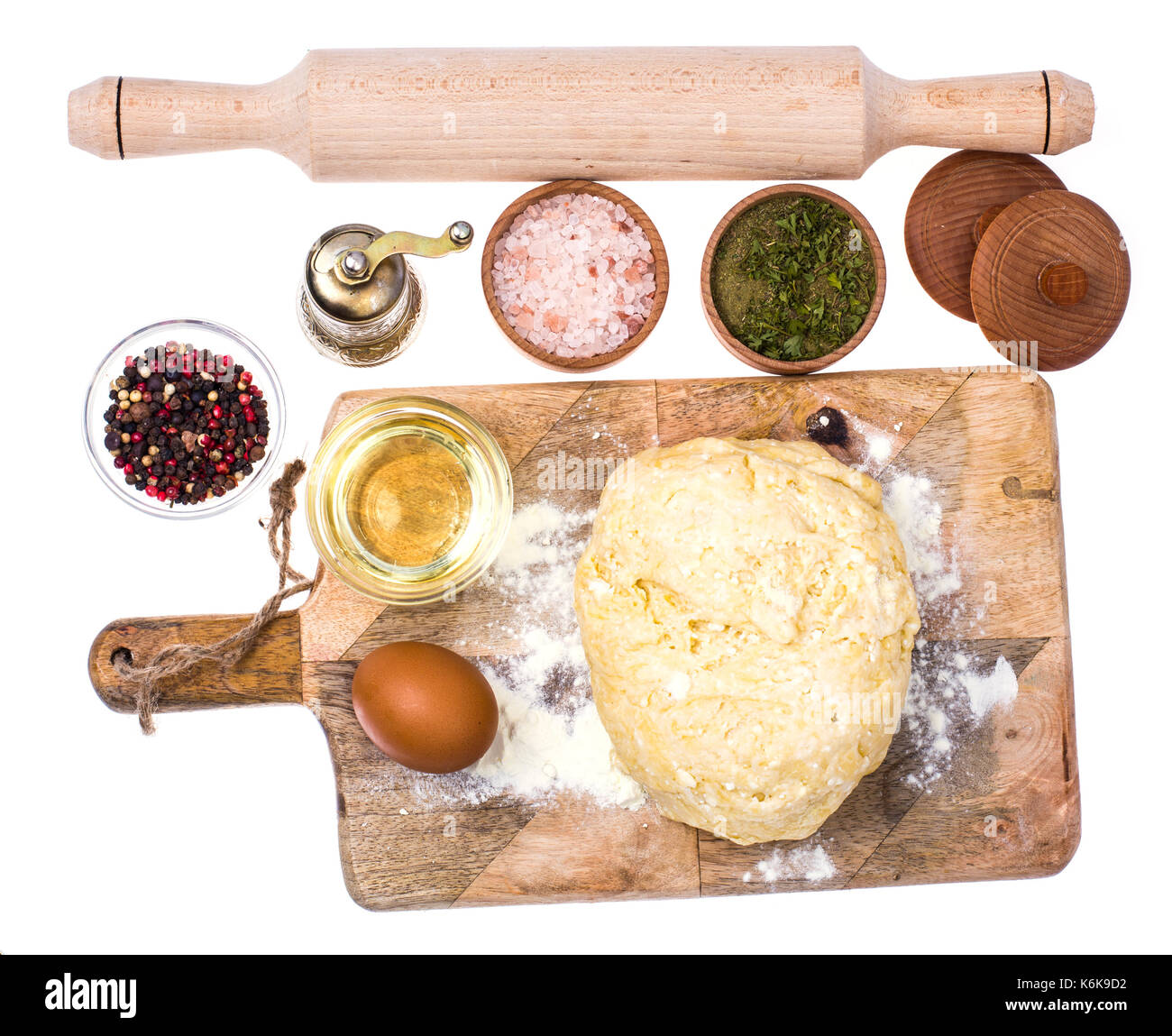 Ball of pizza dough on wooden kitchen cutting board with dusting of