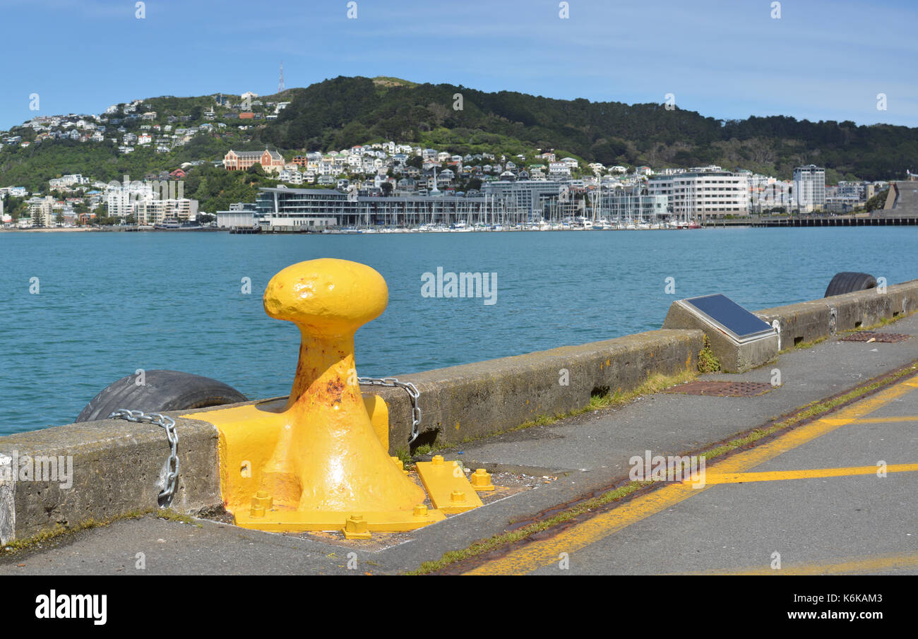 Yellow Bollard on the Wellington Harbour Waterfront and Mount Victoria in the background, New Zealand. Stock Photo