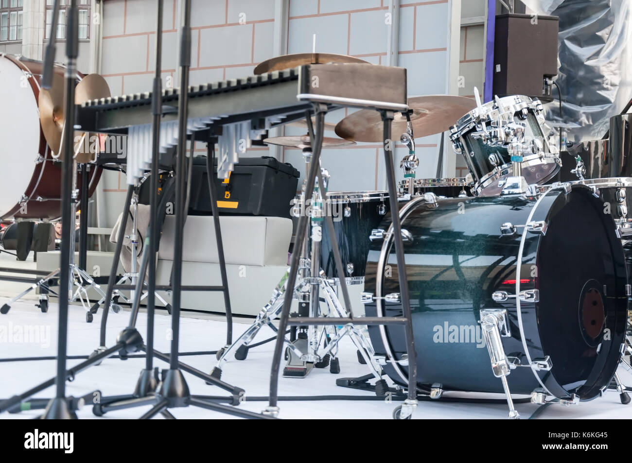 A drum set, a musical instrument, stands on the stage in the street
