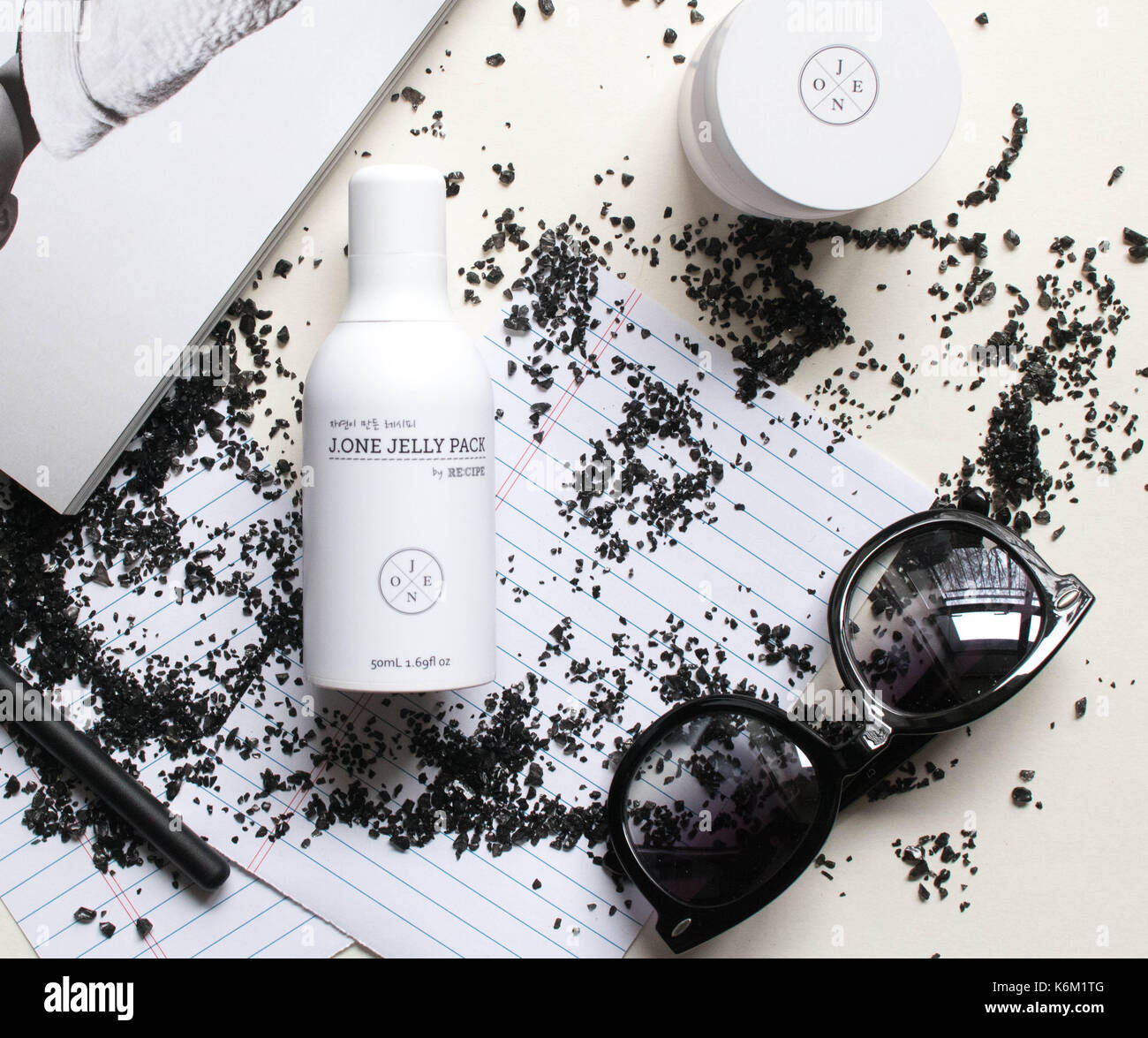 Moisturizer and sunglasses with notebook and magazine Stock Photo
