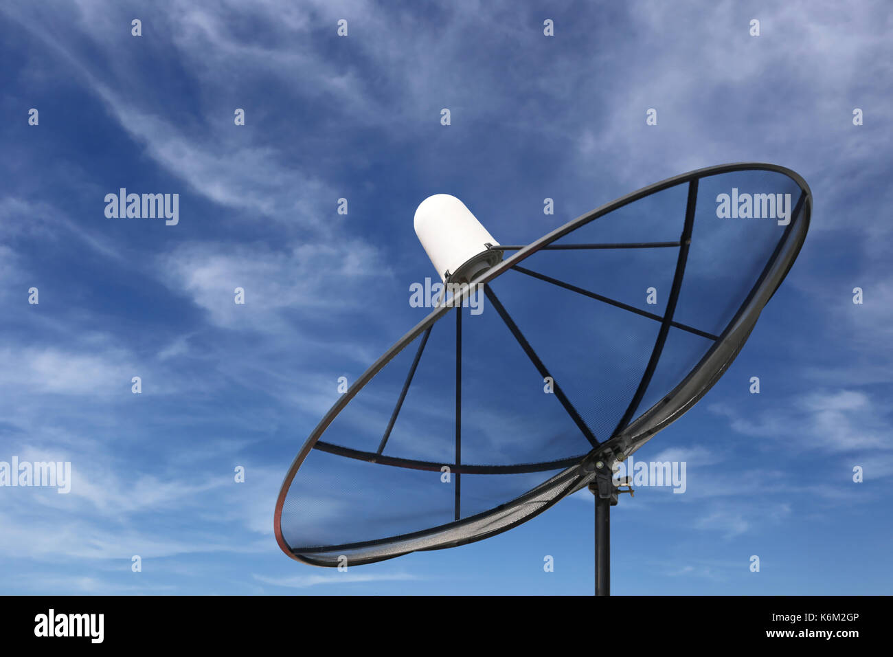 Black Satellite dish on blue sky background. Stock Photo