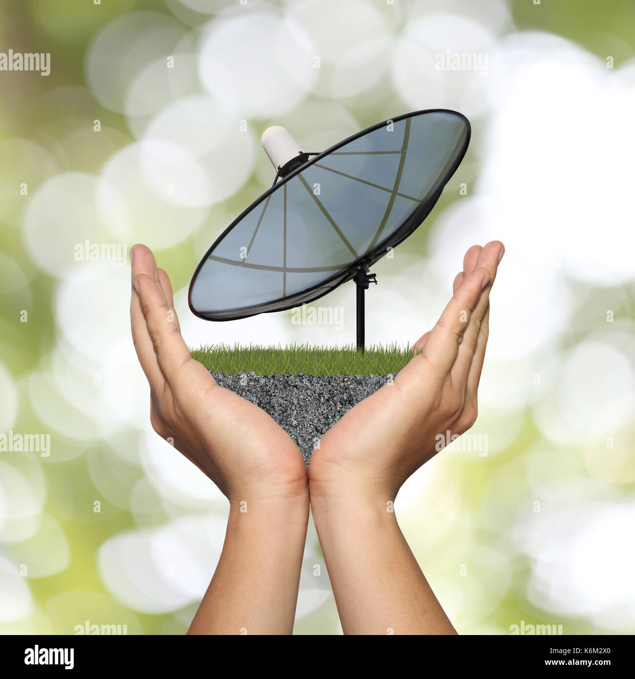 Black Satellite dish in hand of businessman and have Skyscraper on green bokeh background,Concept of data communication. Stock Photo