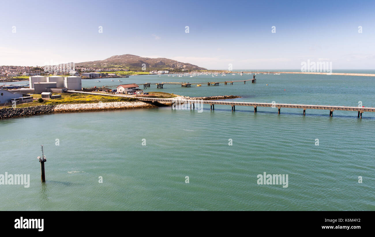 Piers and fuel tanks at Holyhead Port in North Wales, with Holyhead town and Holyhead Mountain behind. Stock Photo
