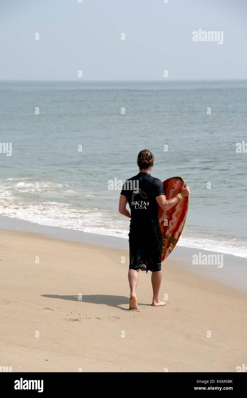 Male skimboard competitor awaits the next wave. Stock Photo