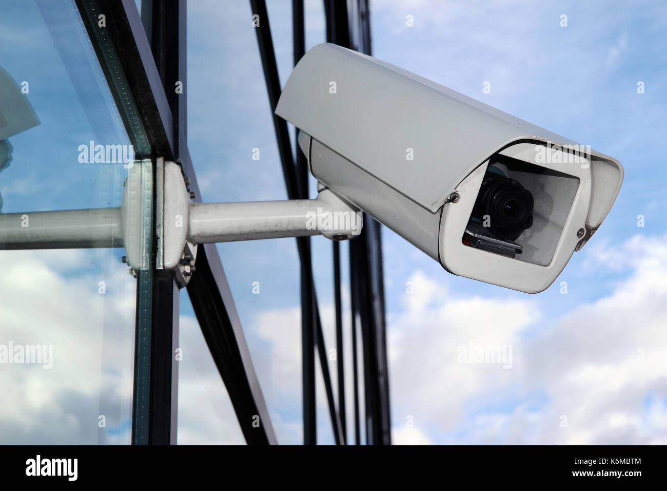Digital CCTV camera on the glass facade Stock Photo