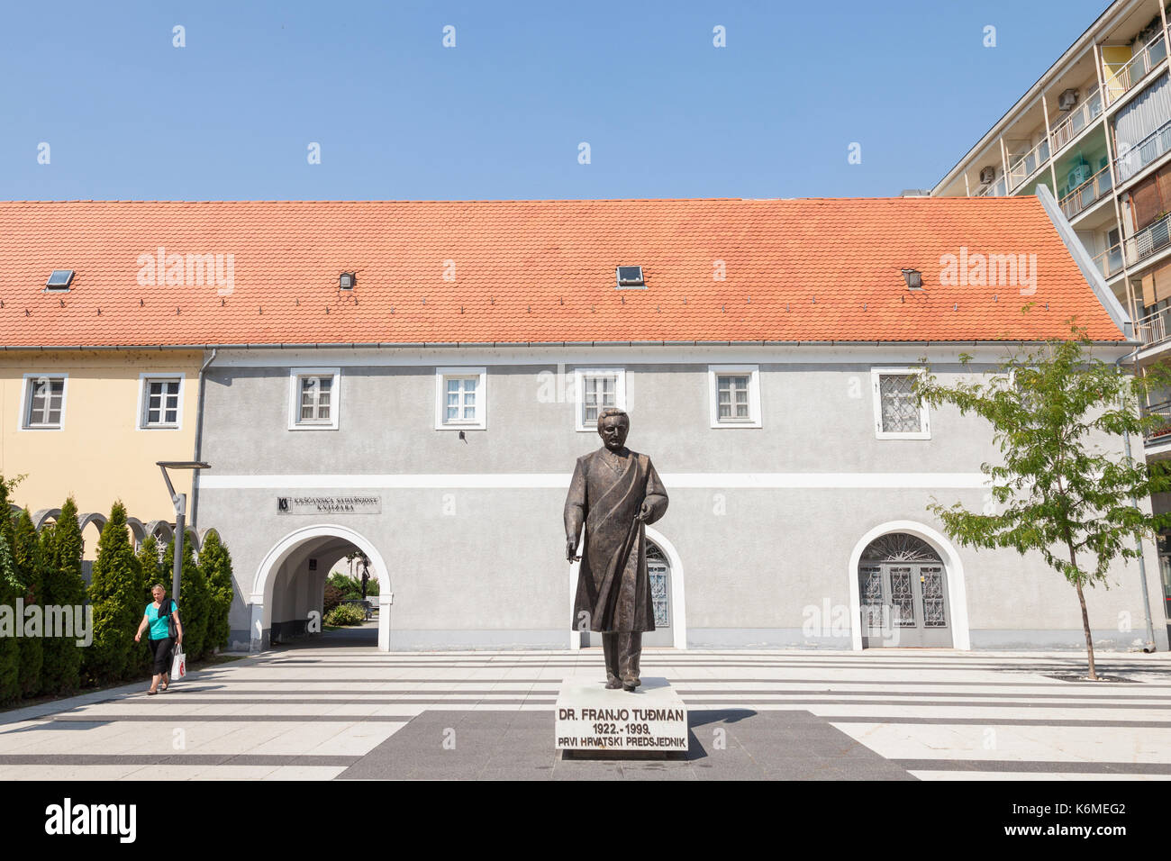 OSIJEK, CROATIA - AUGUST 26, 2017: Woman passing by a statue of Franjo Tudman. Franjo Tudjman was the first president of Croatia, during the 90's  Fra Stock Photo