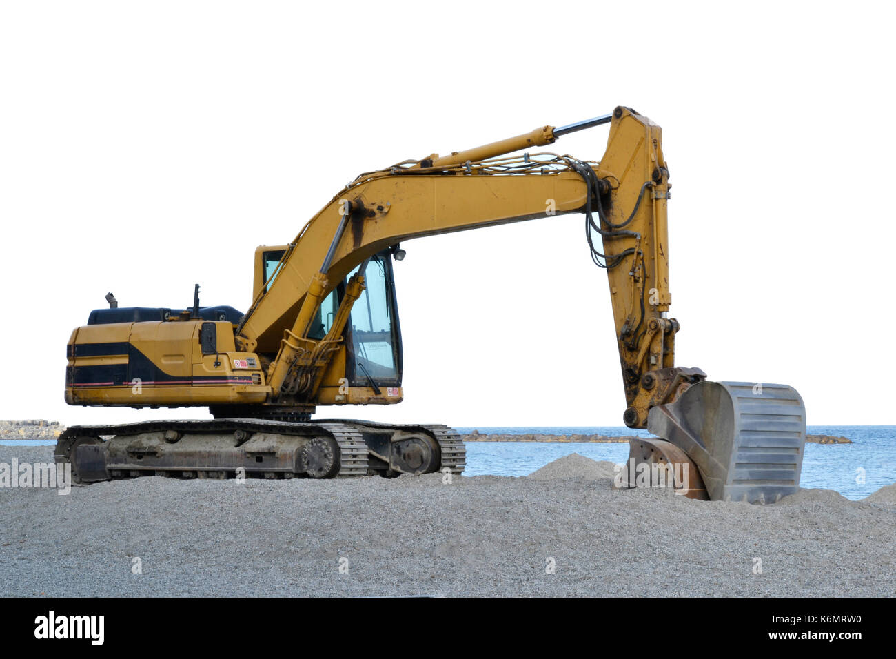 excavator that is working on the beach to smooth the sand before the