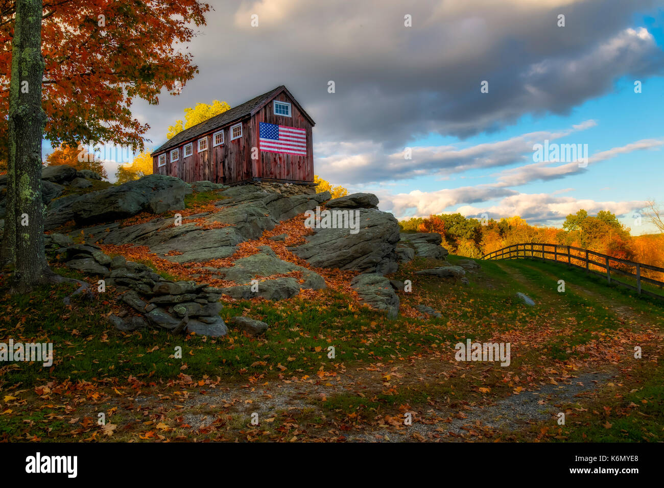 USA Patriotic Rustic Barn - This red rustic barn stands tall on granite and proudly displays the United States of America Flag. It is part of what makes up the Greyledge Farm in Roxbury, Connecticut. Stock Photo