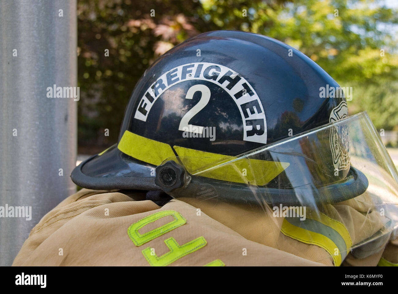 firefighter black helmet with number and face shield on coat Stock