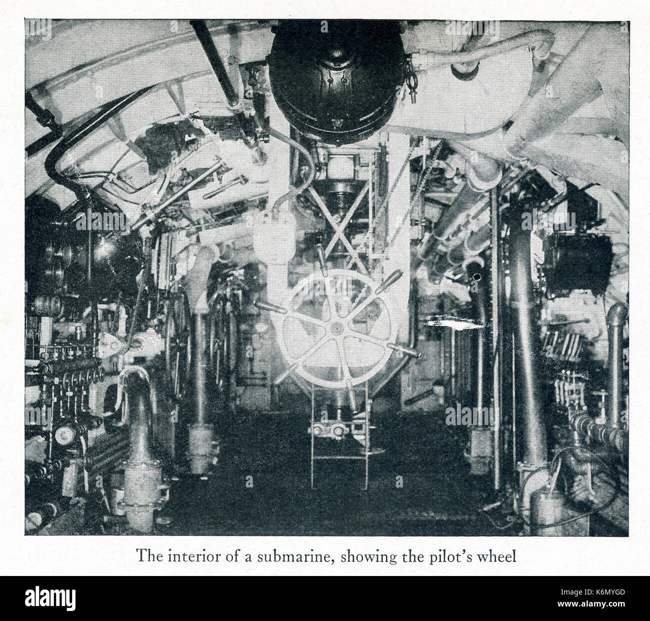 This photo taken during World War I shows the interior of a submarine, showing the pilot's wheel. Stock Photo