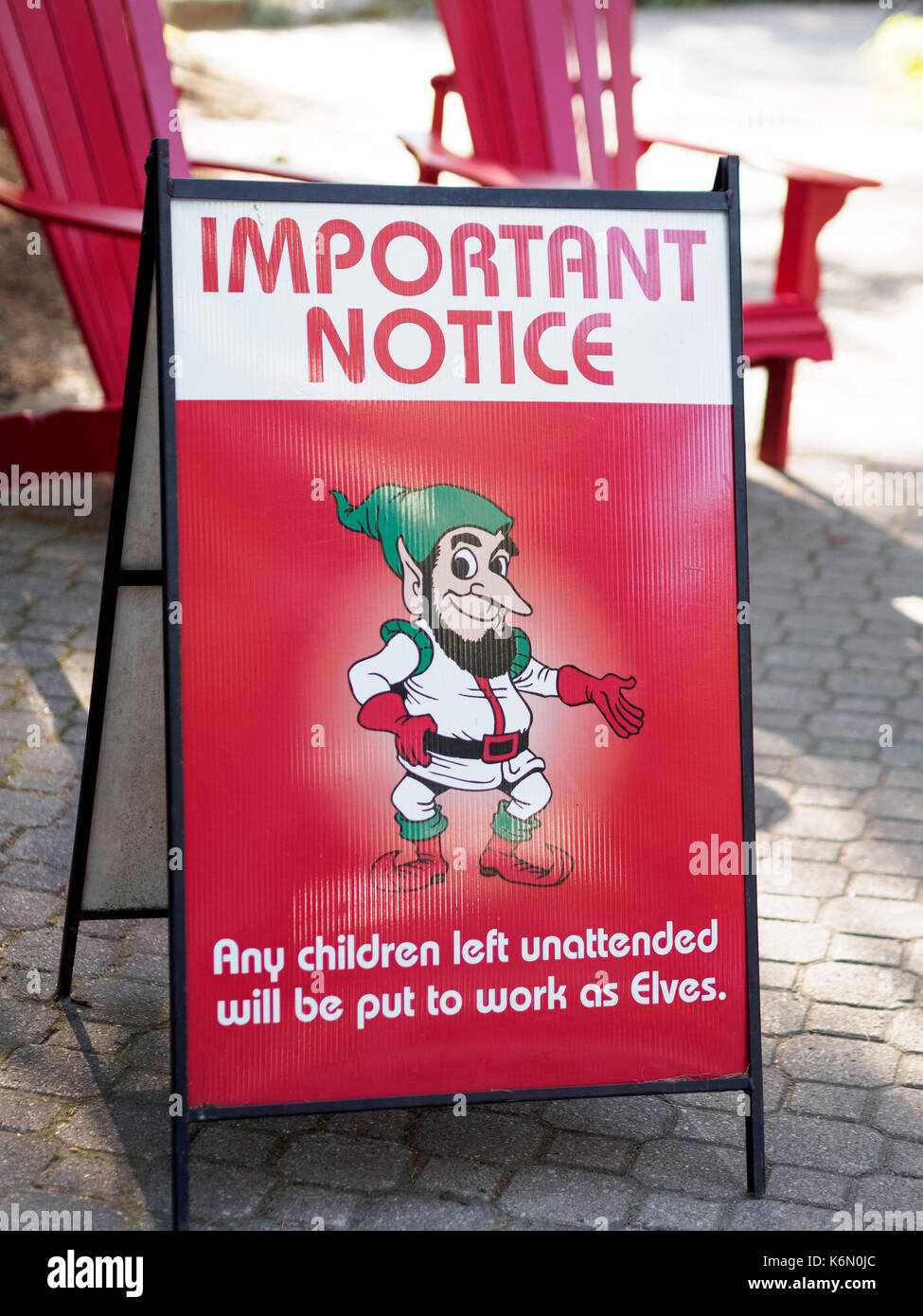 A sign reading any children left unattended during holiday time will be put to work as Elves. A fun way to put notice to have kids in parent's watch. Stock Photo