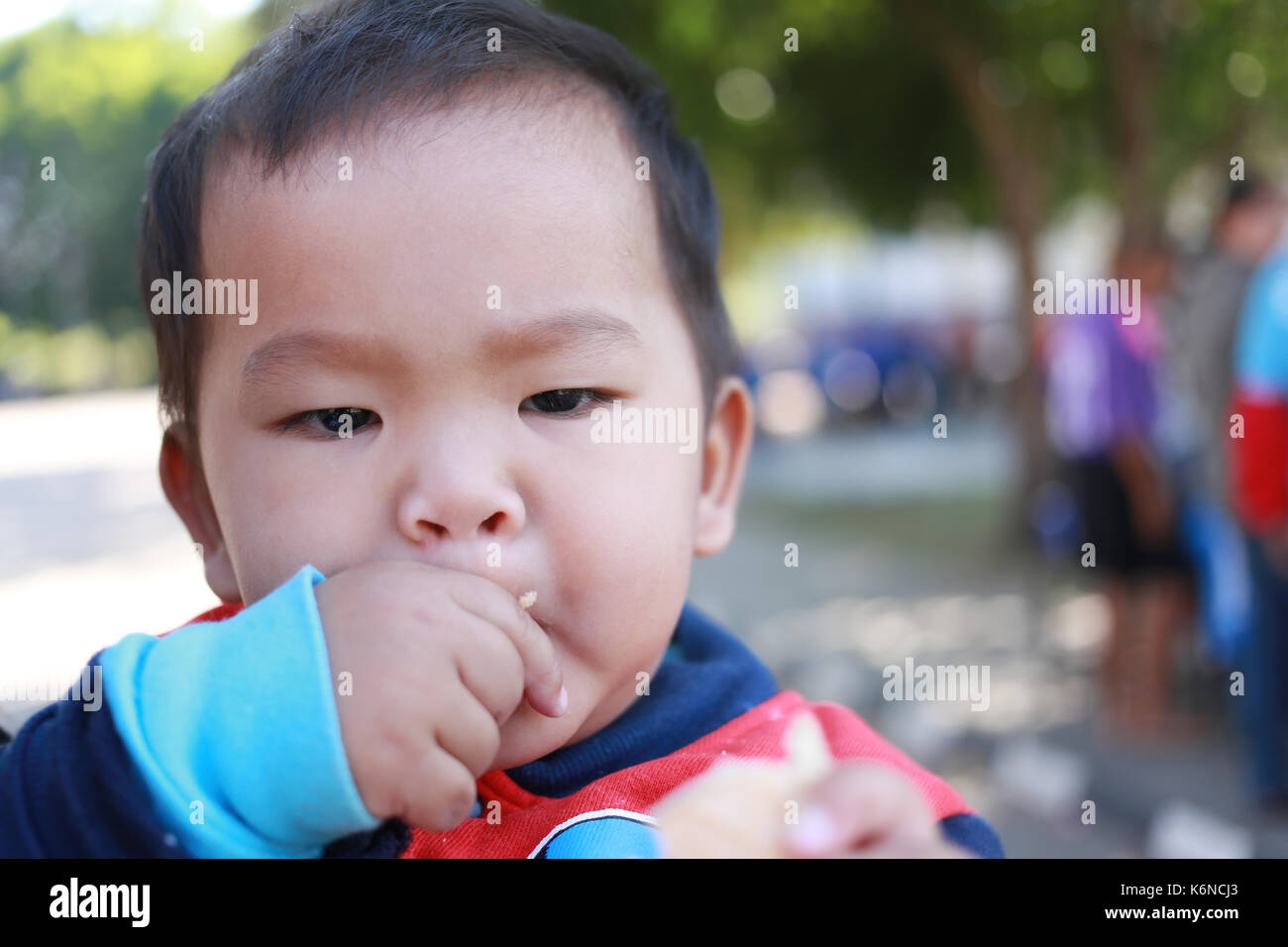 Asian boy faces eating sweets with pleasure,concept of food and health of children. Stock Photo