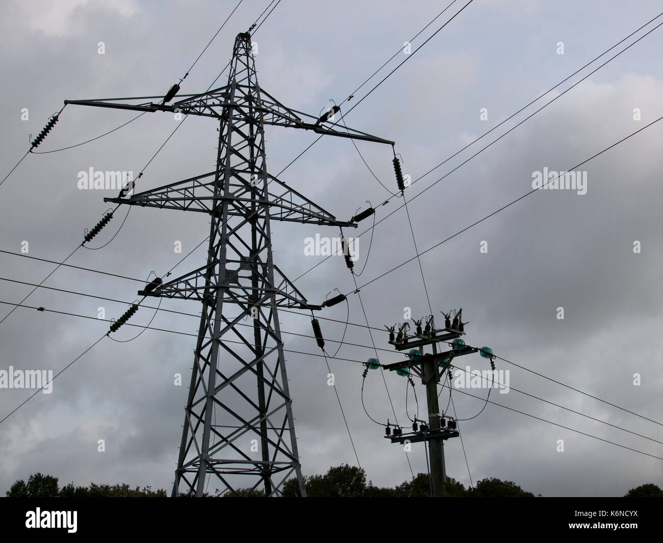 Electricity Pylon set against a grey cloudy sky Stock Photo - Alamy