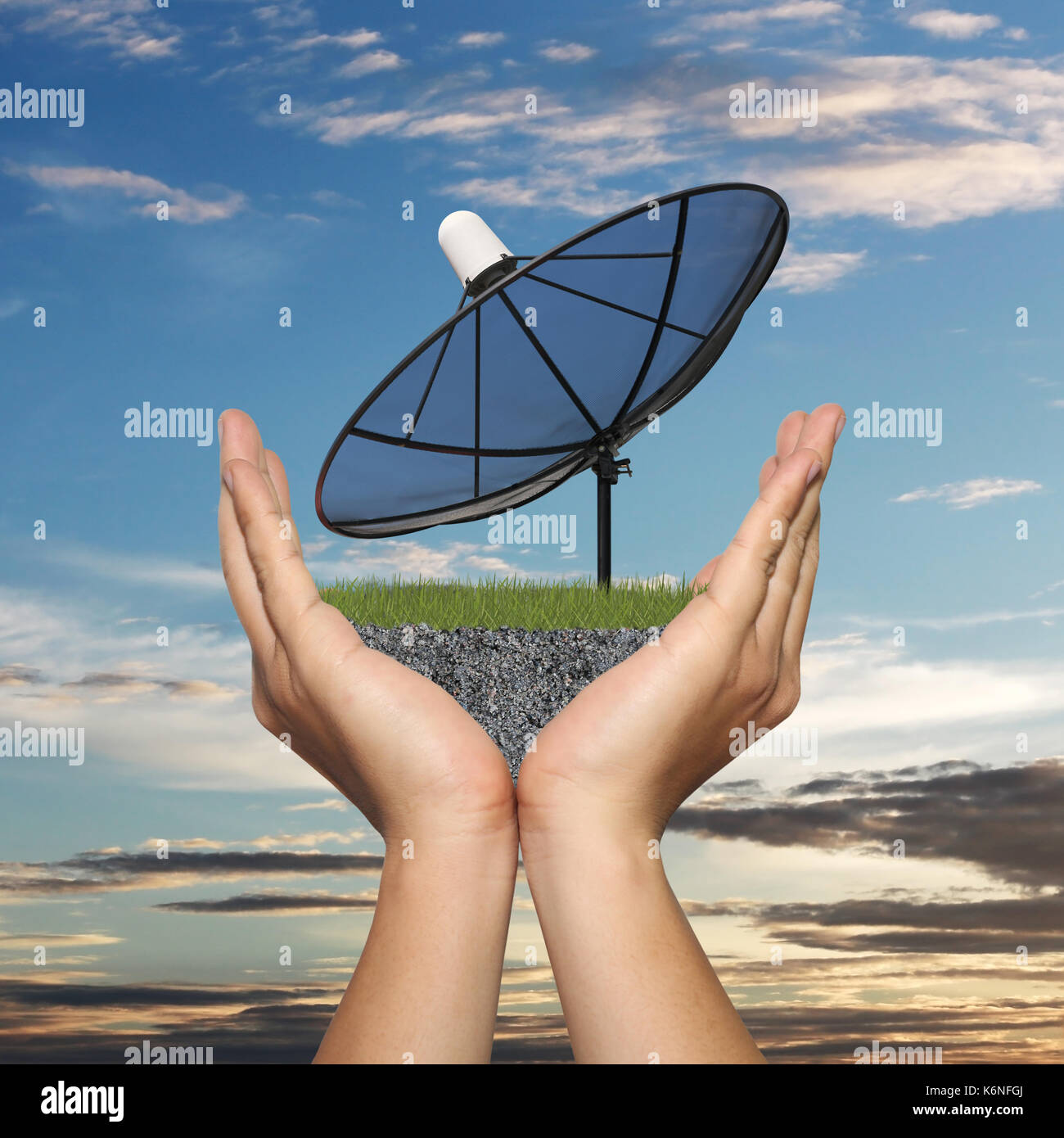 Black Satellite dish in hand of businessman on sunset background,Concept of data communication. Stock Photo