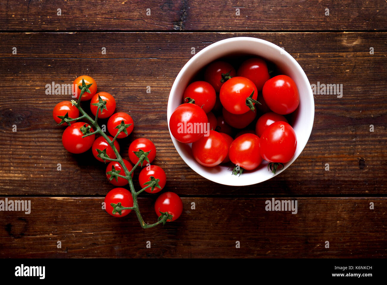 Bright red juicy tomatoes in a bowl on wood Stock Photo - Alamy