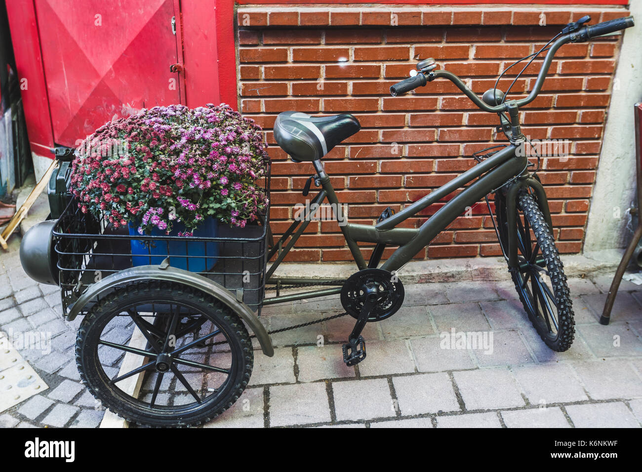 Street decoration with old bicyle and big basket of flowers Stock Photo