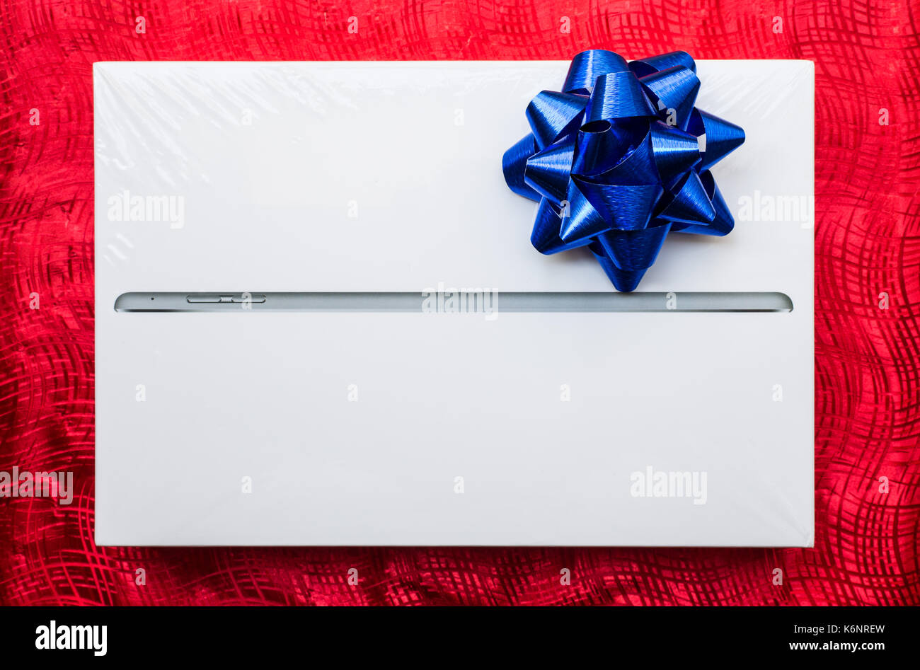 tablet in box for gift on red gift wrap Stock Photo