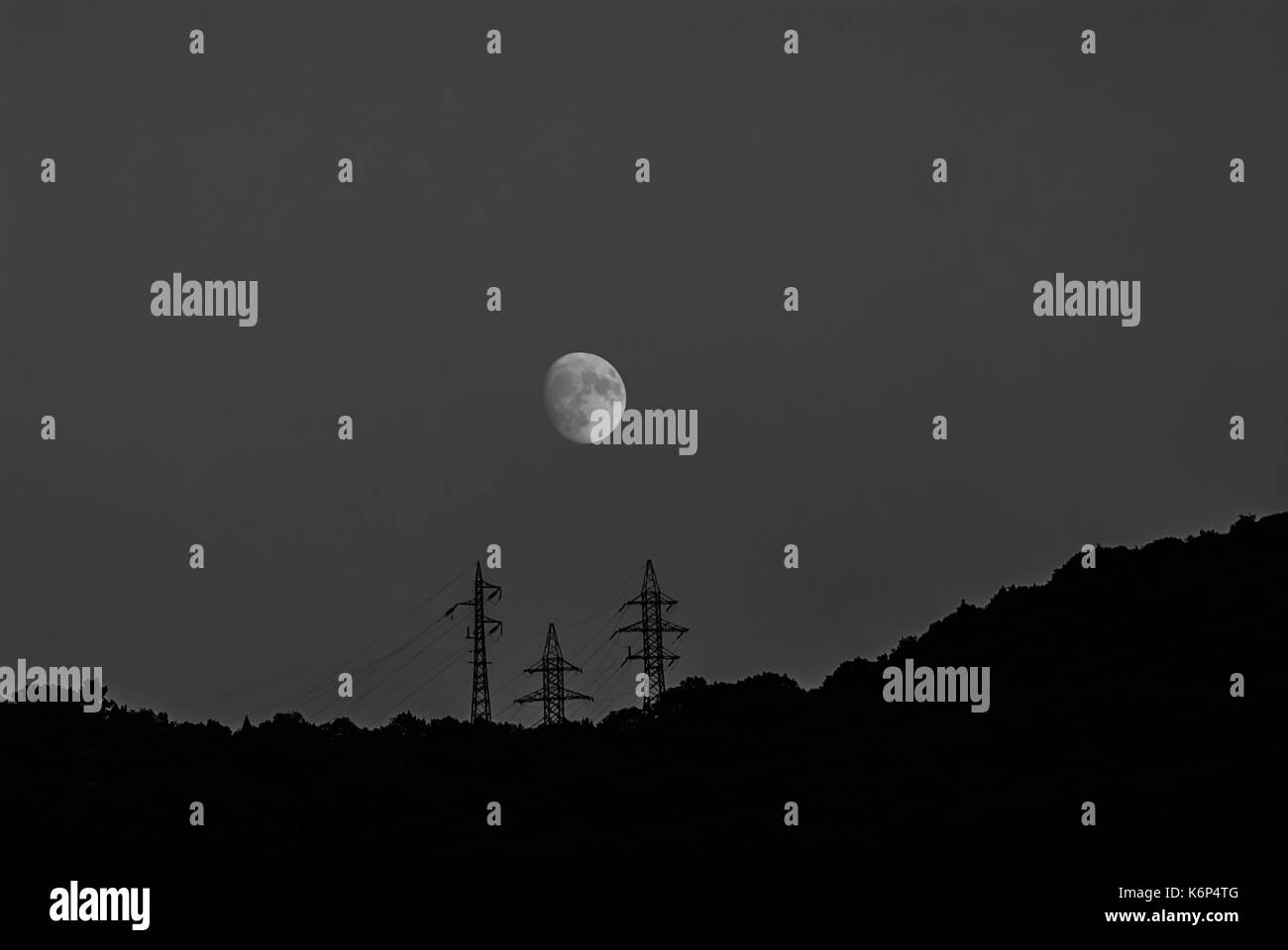 Night landscape in the mountains of the moon and power line. Background for web page design. Stock Photo