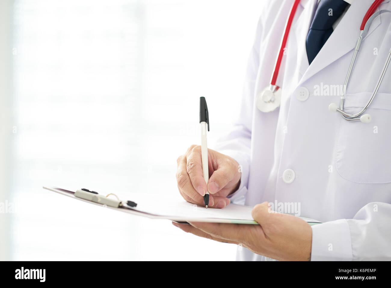 Doctor with a stethoscope and taking notes with bright background . Stock Photo