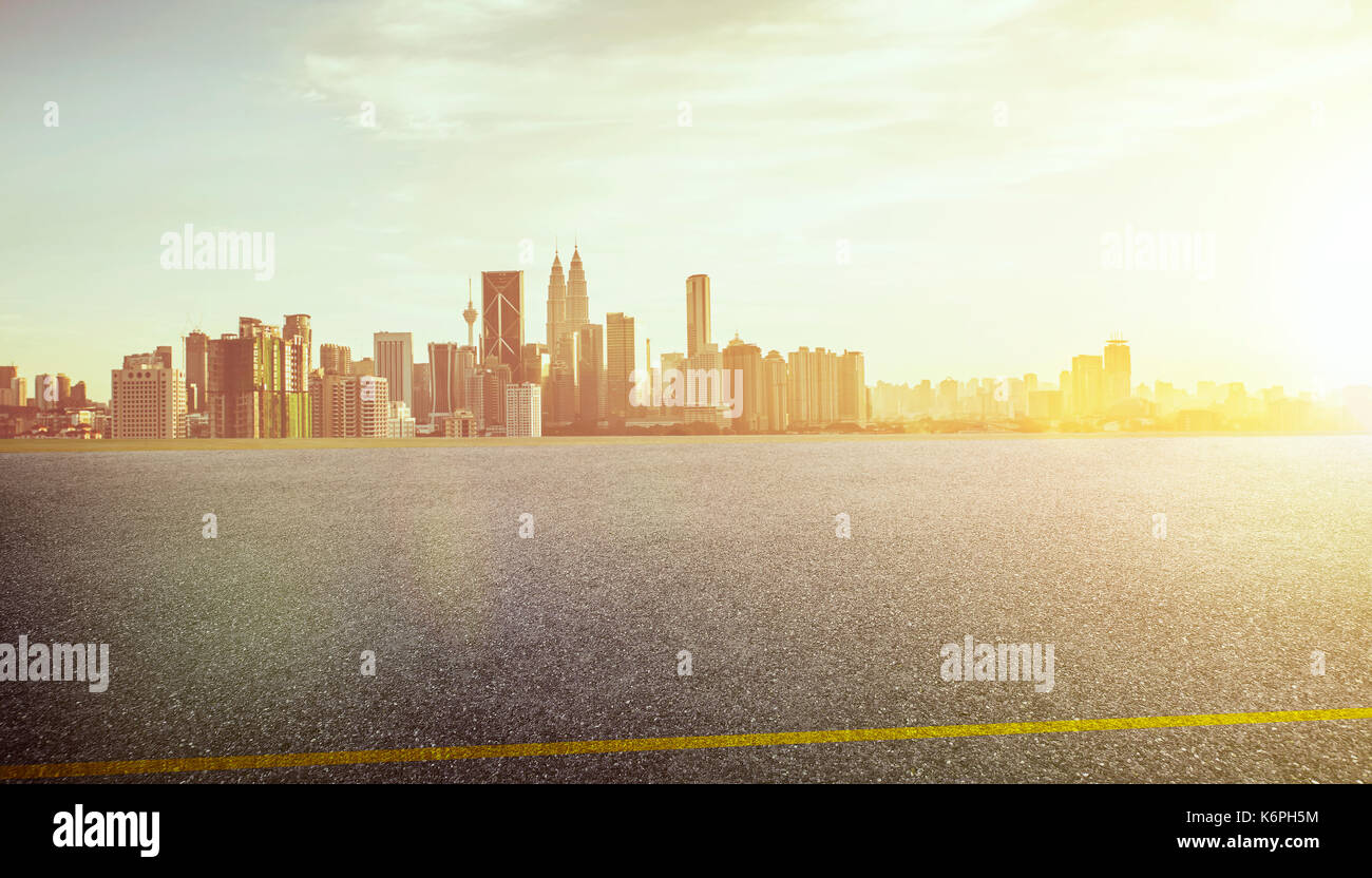 View of the empty asphalt road with city skyline background . Sunset ...