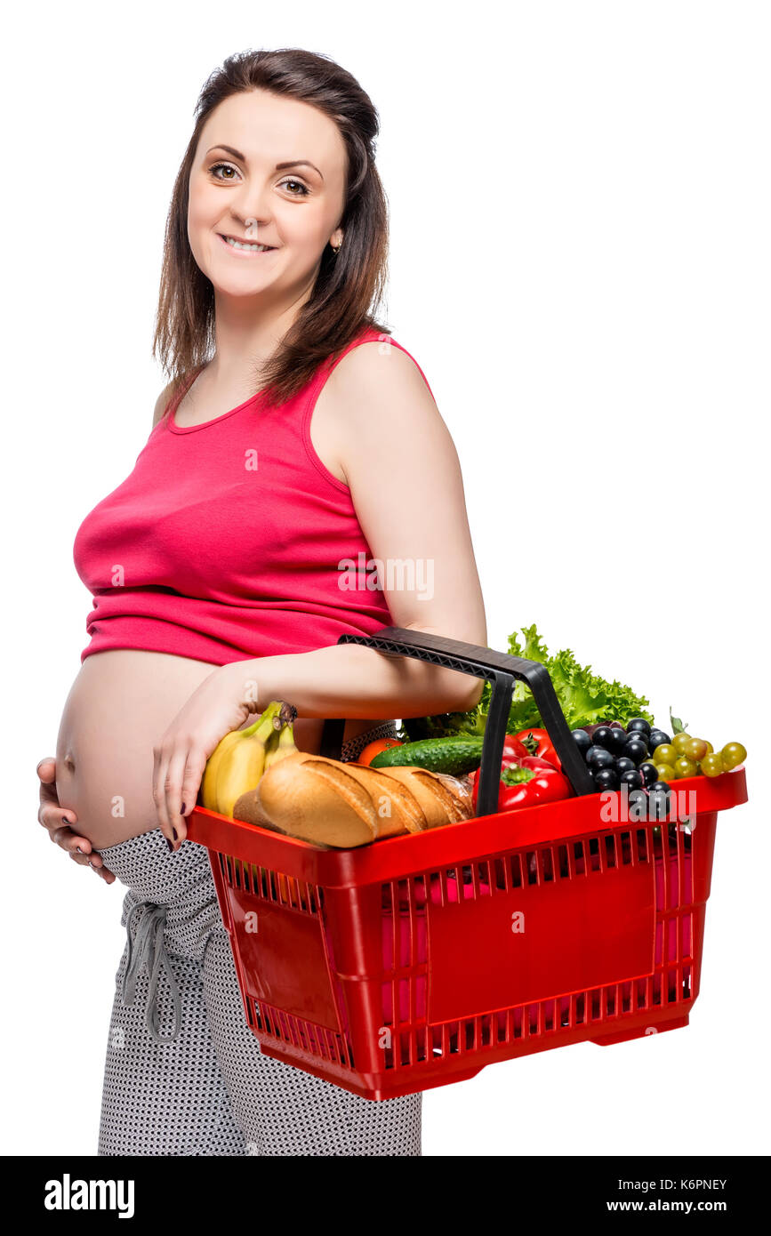 Young pregnant woman with basket of fruits and vegetables on white ...