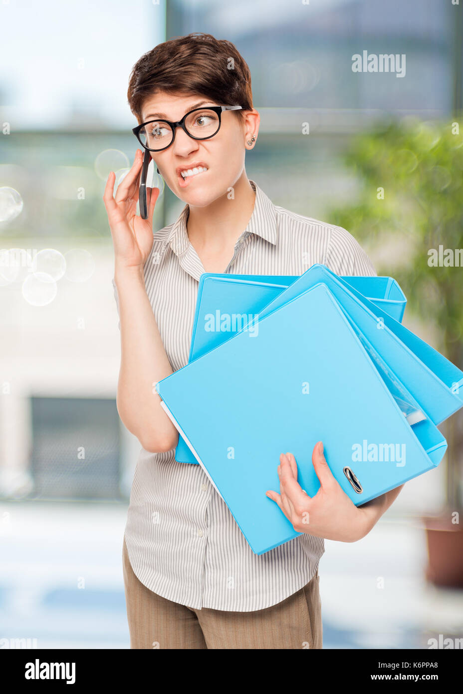 emotional baffled girl talking on the phone with the boss in the office Stock Photo