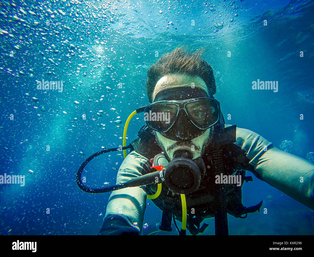 Underwater scuba diver with all the equipment looking at camera Stock