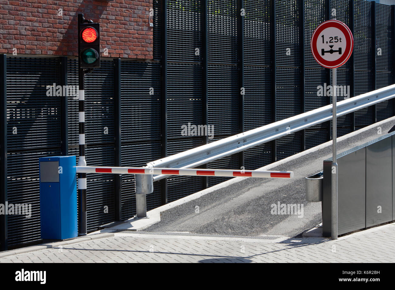 Parking garage ramp with barrier and a red light. Wait for the green light. Stock Photo