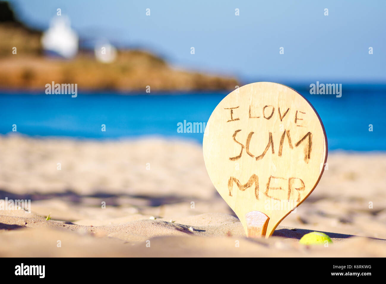 A racket on the beach with written message