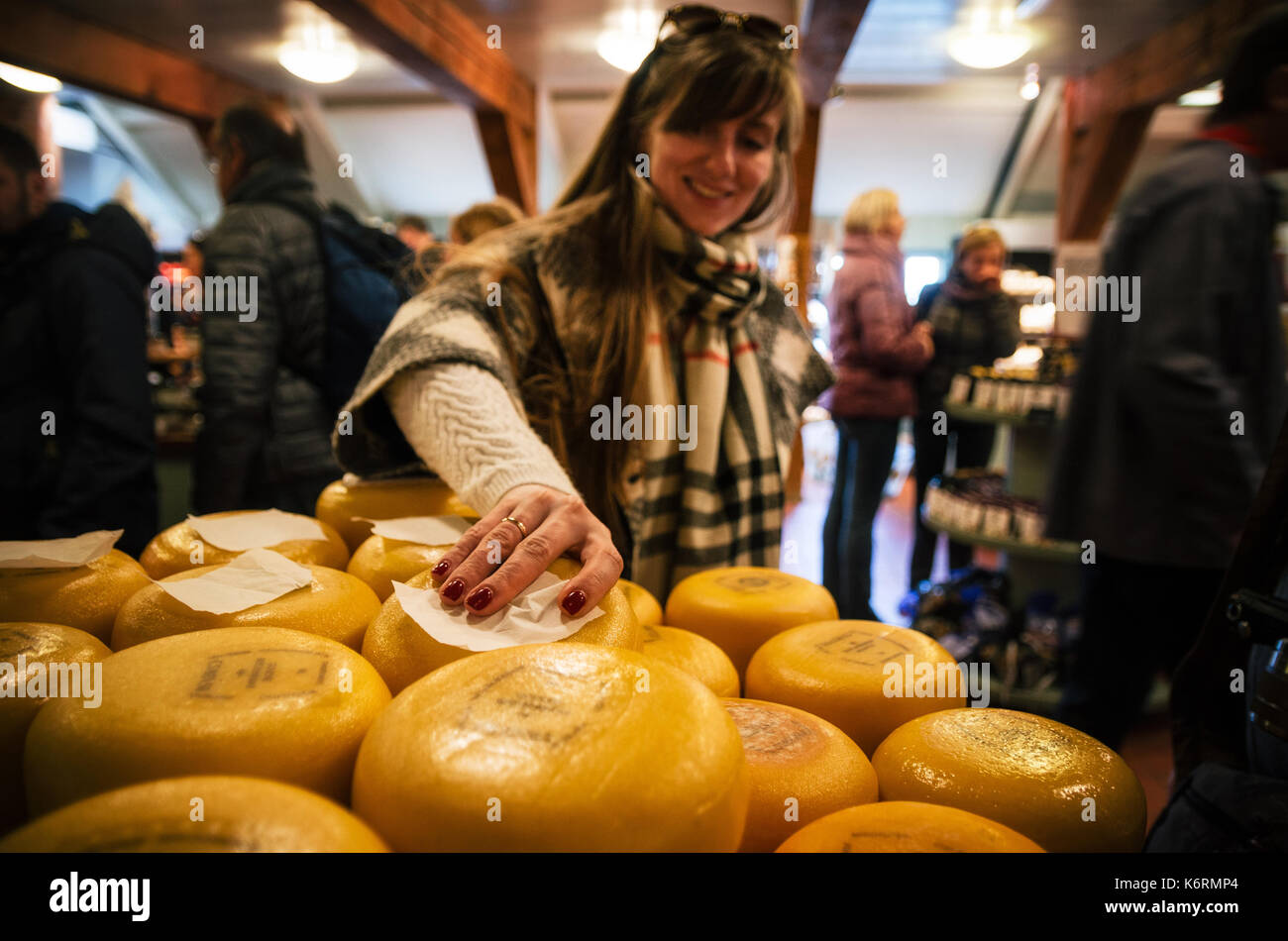Zaanse Schans, Netherlands - April 26, 2017: Young woman takes Dutch cheese in shop in Zaanse Schans traditional village Stock Photo