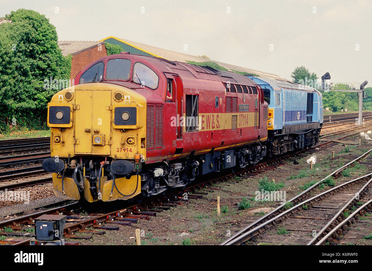 A class 37 locomotive leaves Eastleigh with a Class 58 locomotive in tow. Stock Photo