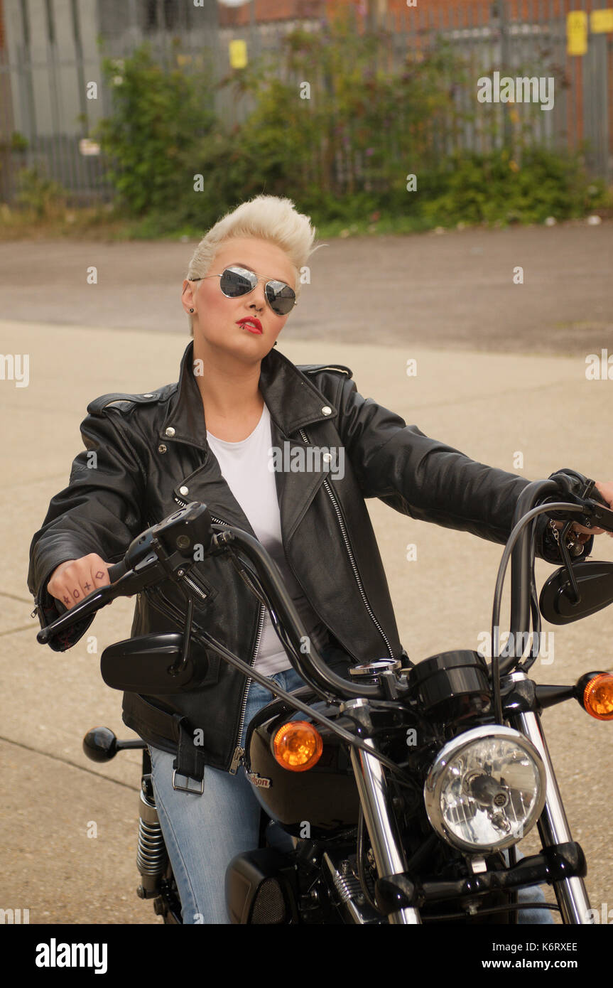 Beautiful shorthaired blonde girl with a Harley Davidson motorcycle