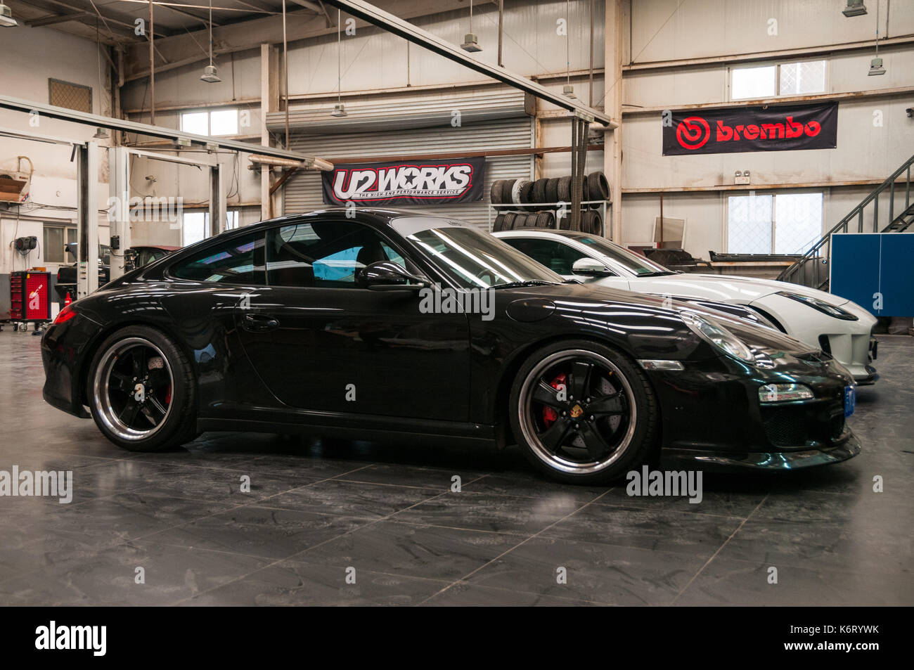 Porsche 911 and Jaguar F-type in the workshop of U2 cars in the Fengyiqiao area of Beijing. Stock Photo
