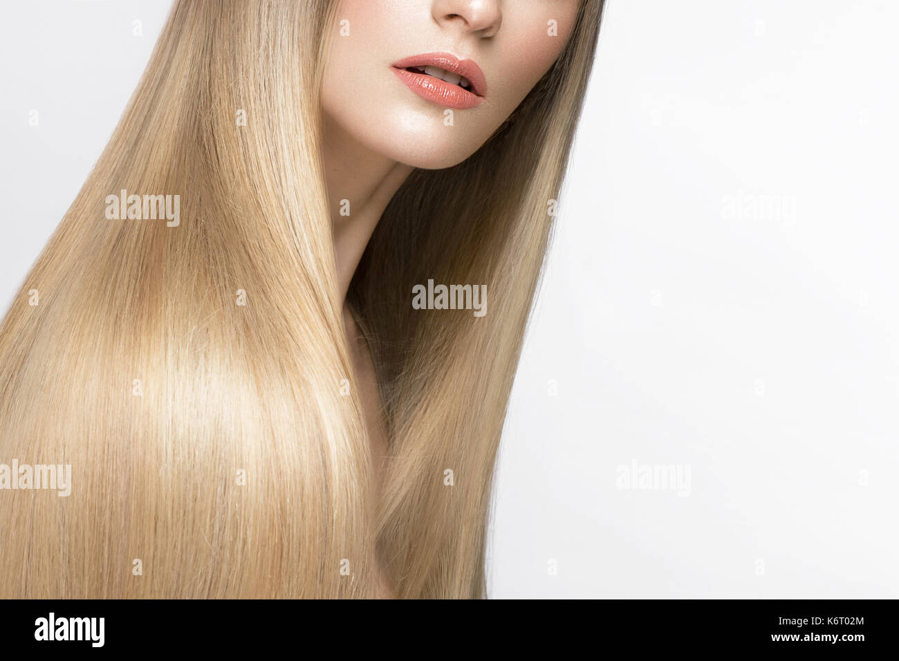 Beautiful blond girl with a perfectly smooth hair, and classic make-up. Beauty face. Stock Photo