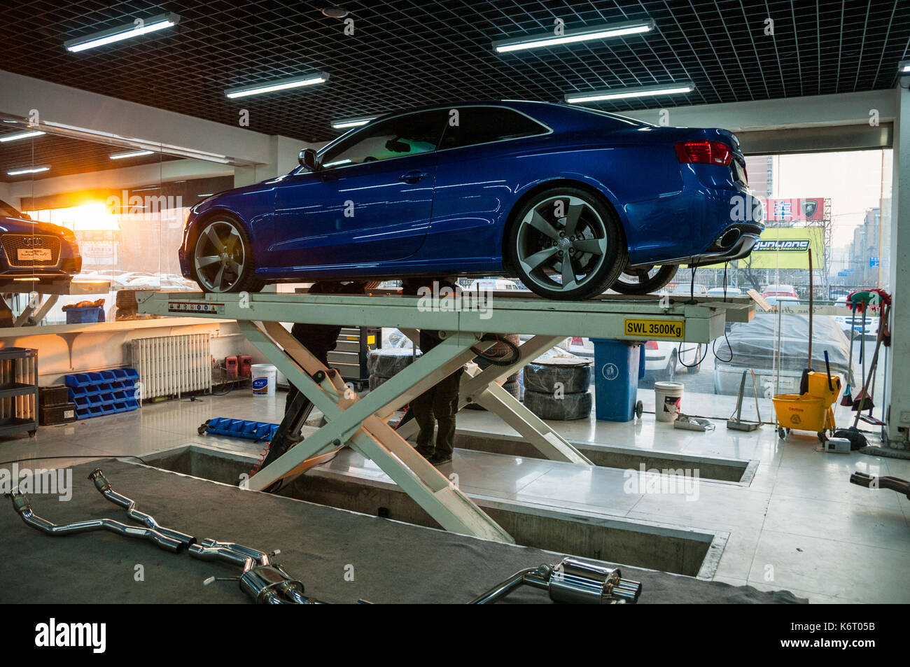 Ma Yuan's Audi RS5 receiving a new exhaust system at a workshop on the Beijing Tuning Street. Stock Photo