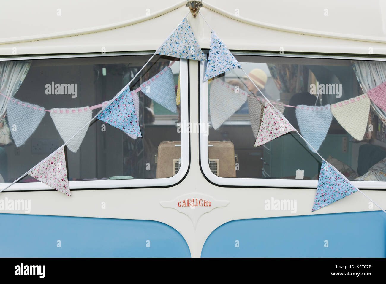 Vintage caravan window detail with floral bunting at a vintage retro festival. UK Stock Photo