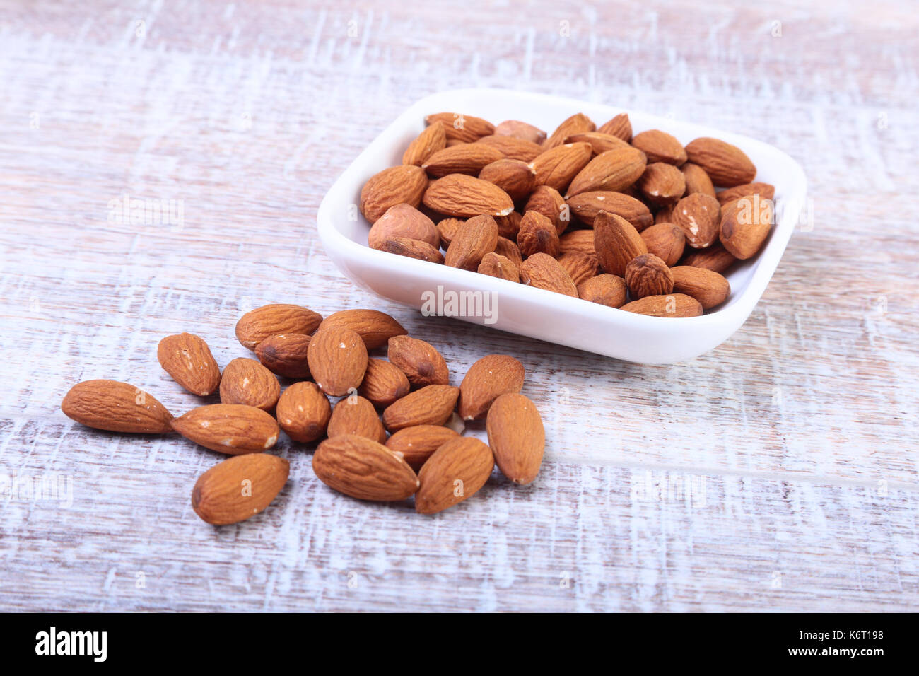 nuts almonds in white bowl on wooden background. Selective focus. Stock Photo