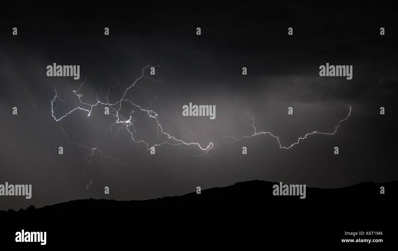 Panoramic view of Lightning strike over mountain range Stock Photo