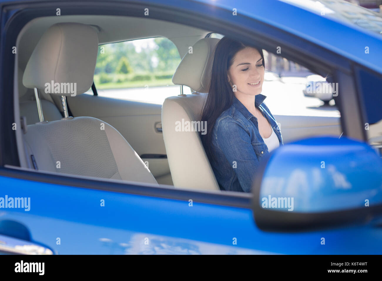 Positive brunette woman sitting in her car Stock Photo - Alamy