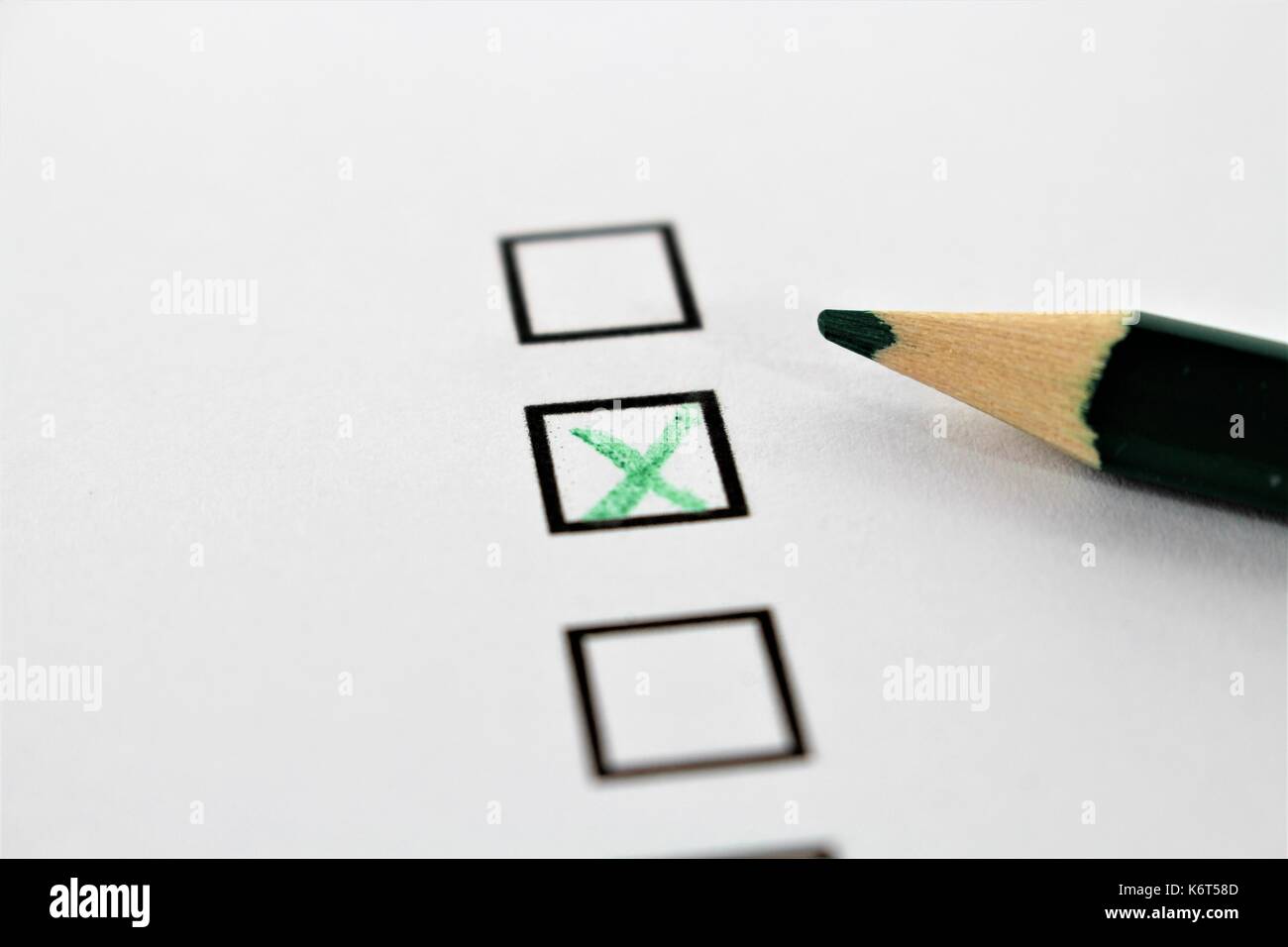 An concept Image of a green pencil and a questionnaire Stock Photo