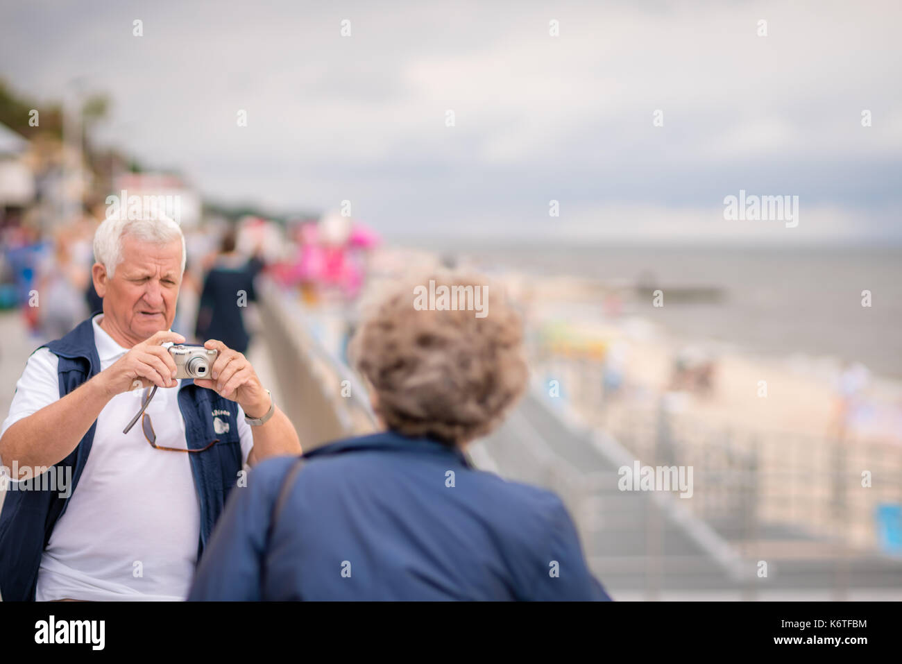 Sarbinowo, Poland -  August 2017 : Older couple taking pictures of themselves on a seafront promenade in a polish resort town Stock Photo
