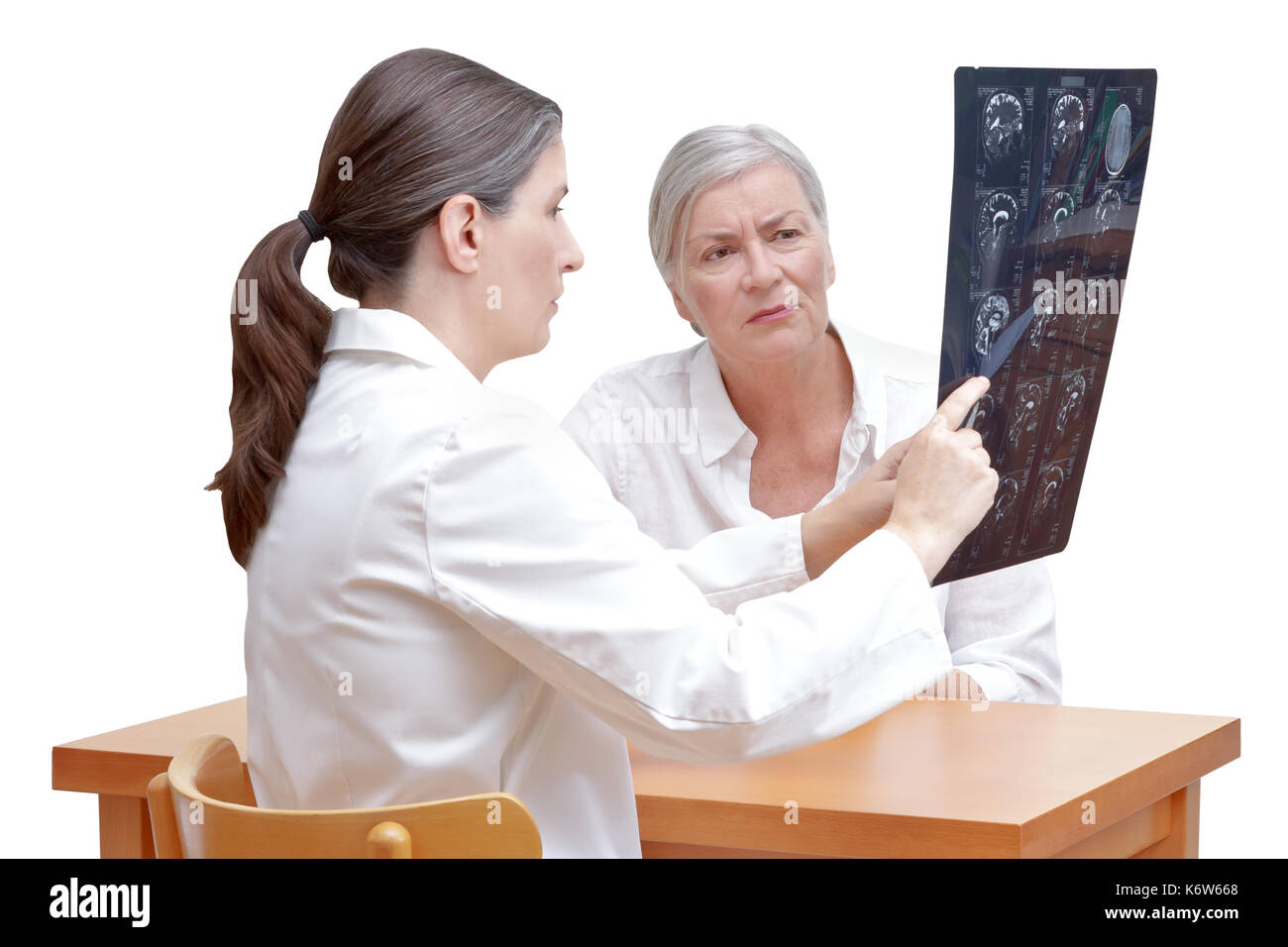 Female middle aged doctor showing her senior patient an mri of her head, isolated on white background Stock Photo