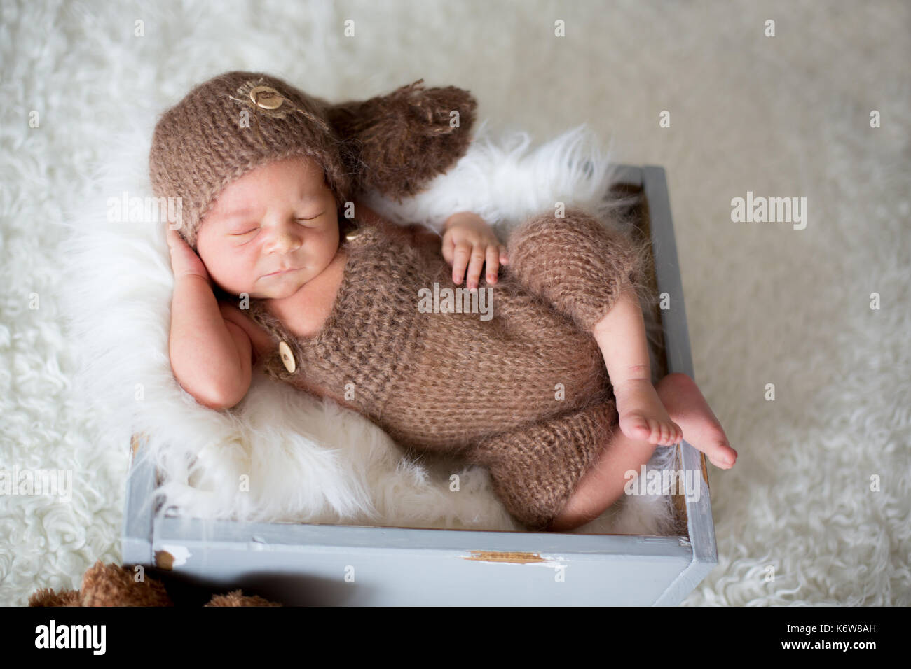 Cute newborn baby sleeps with a toys, teddy bears around him Stock