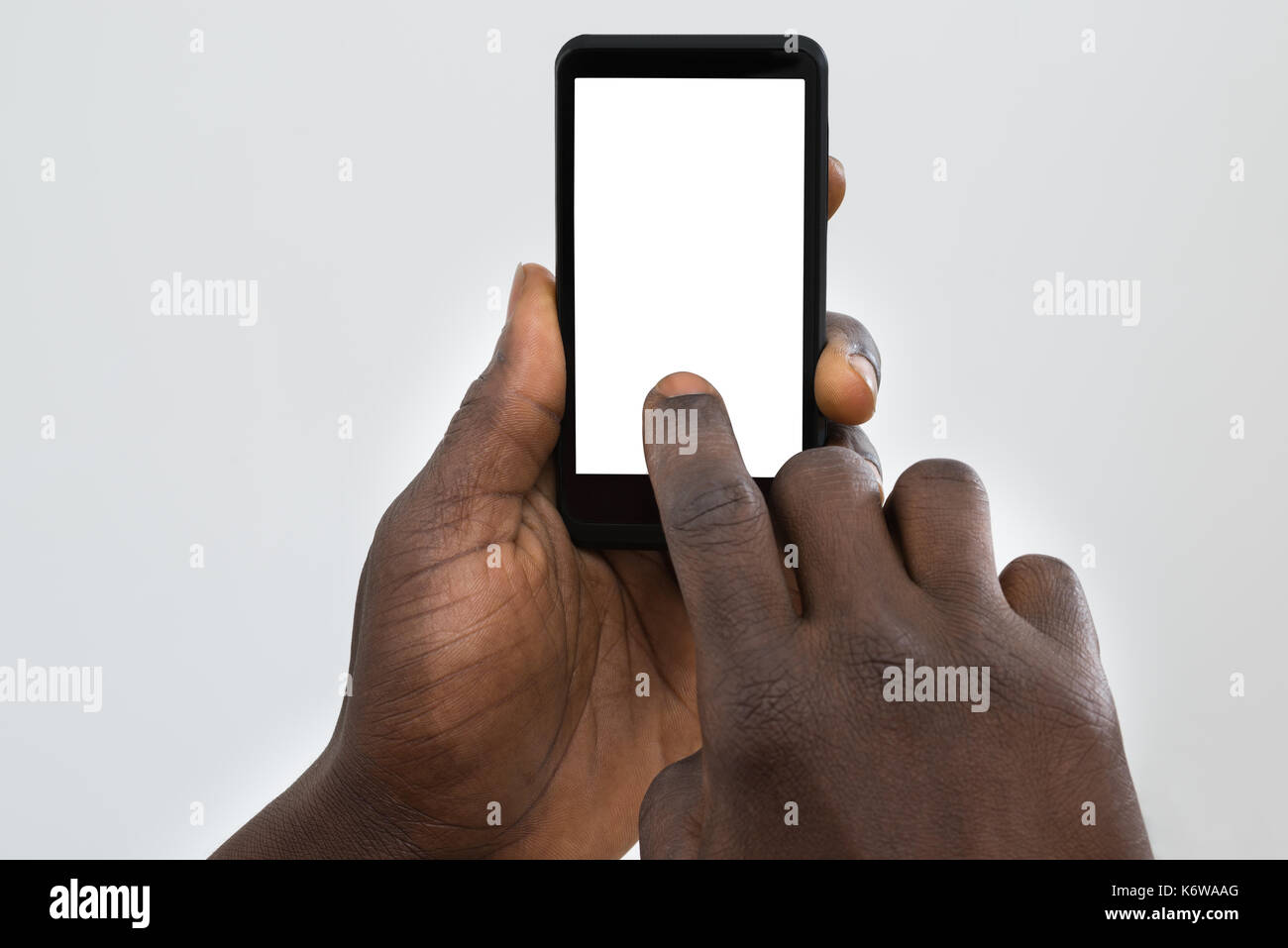 Close-up Of Person's Hand Using Cellphone With Blank Screen Stock Photo