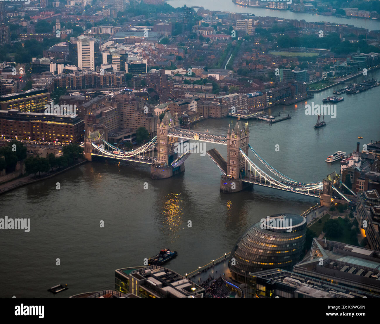 View of opened and illuminated Tower Bridge across the River Thames, with London City Hall, evening, London, England Stock Photo