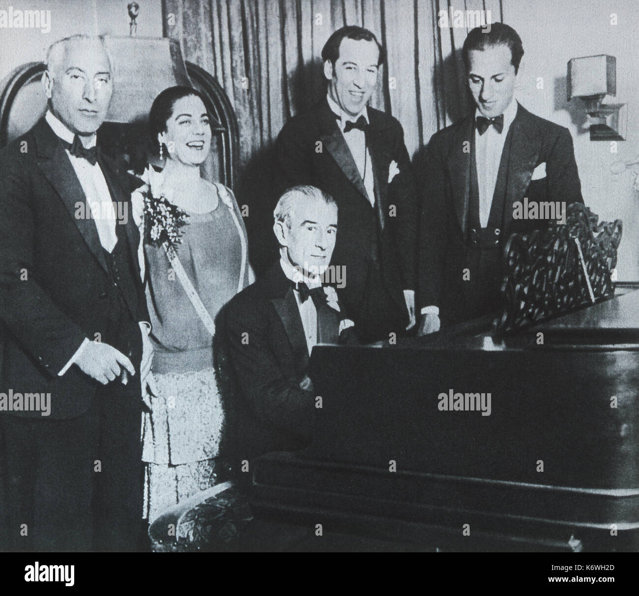 RAVEL, Maurice - playing  Rhapsody in Blue on the piano on his 53rd birthday (1928) for George GERSHWIN (who composed the piece) and friends at Eva Gauthier's party.  French Composer, 1875-1937 Stock Photo