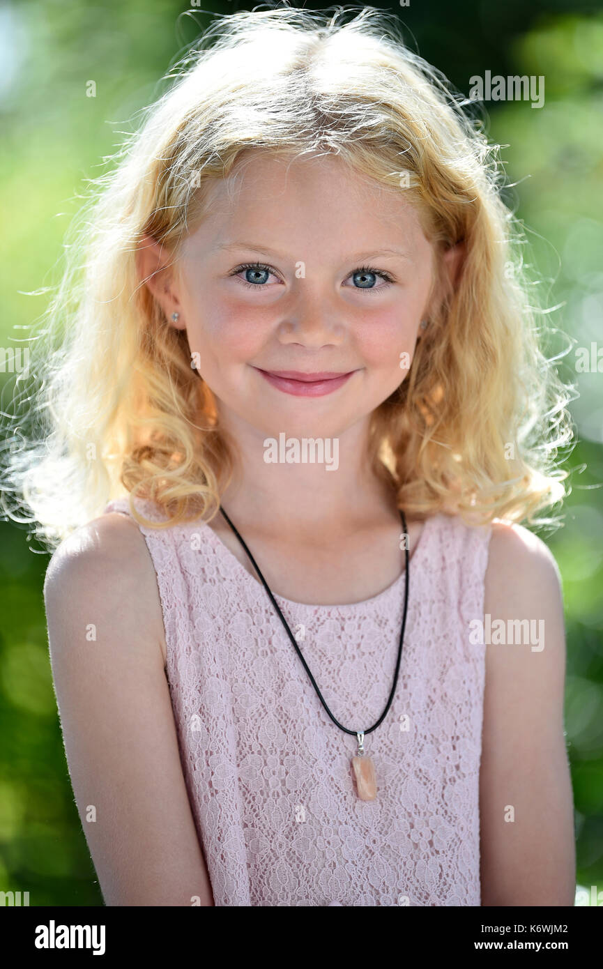 Nude little girl sitting back to us on a light background Stock