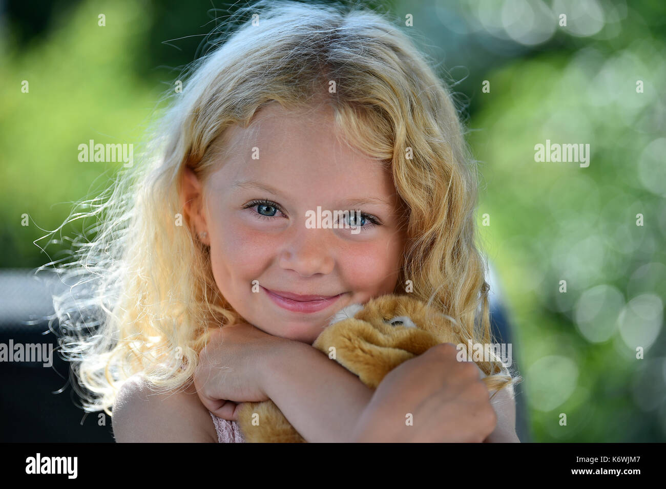 Little girl with blonde hair and cuddly toy, portrait, Sweden Stock Photo