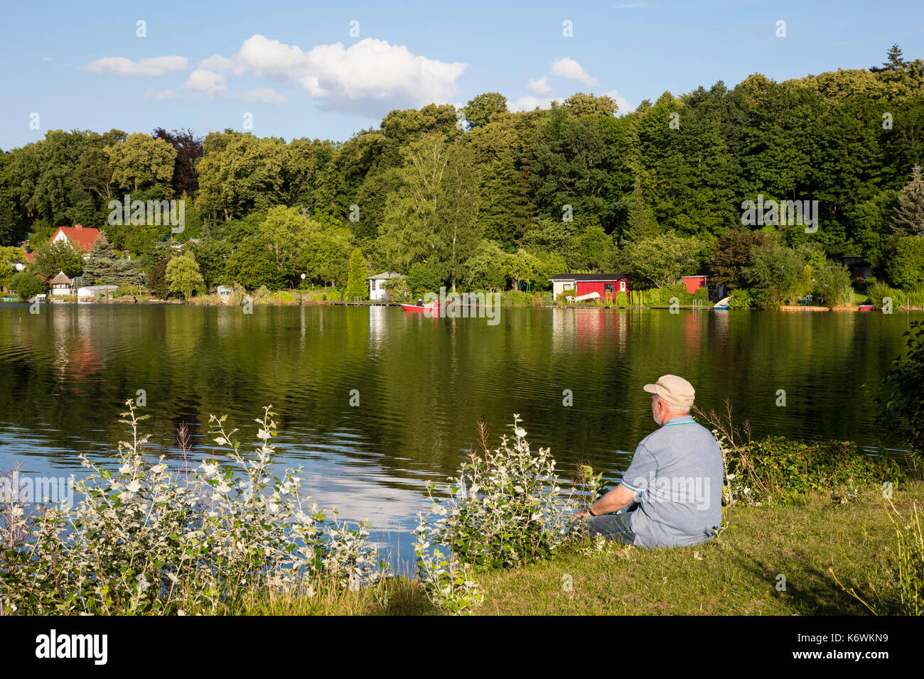 Mann, Senior sits on the lakeside, Tiefenwarensee, Waren, Müritz, Mecklenburg Lake District, Mecklenburg-Western Pomerania Stock Photo